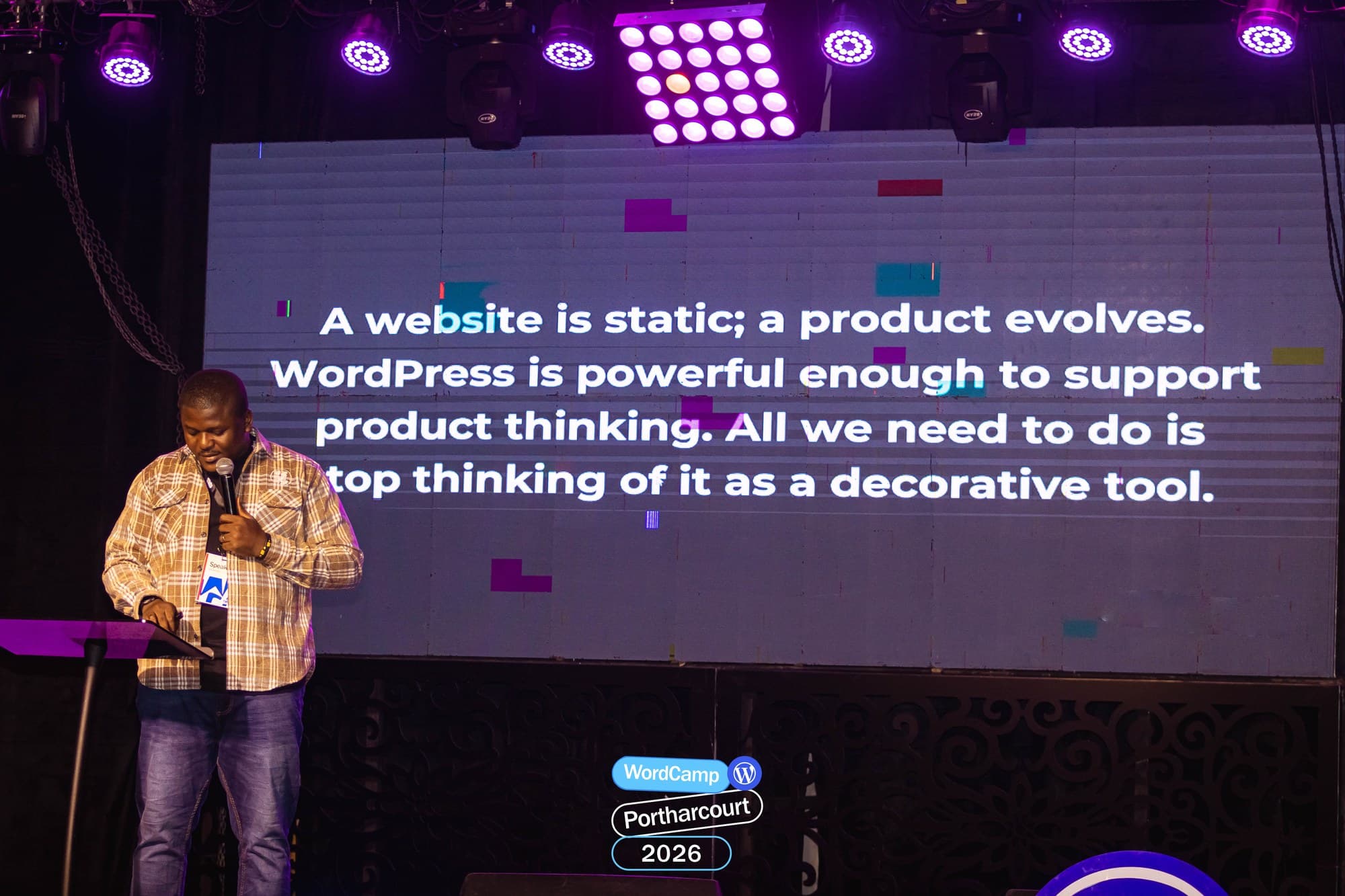 Adebayo Chike on stage beside a slide reading: A website is static; a product evolves.