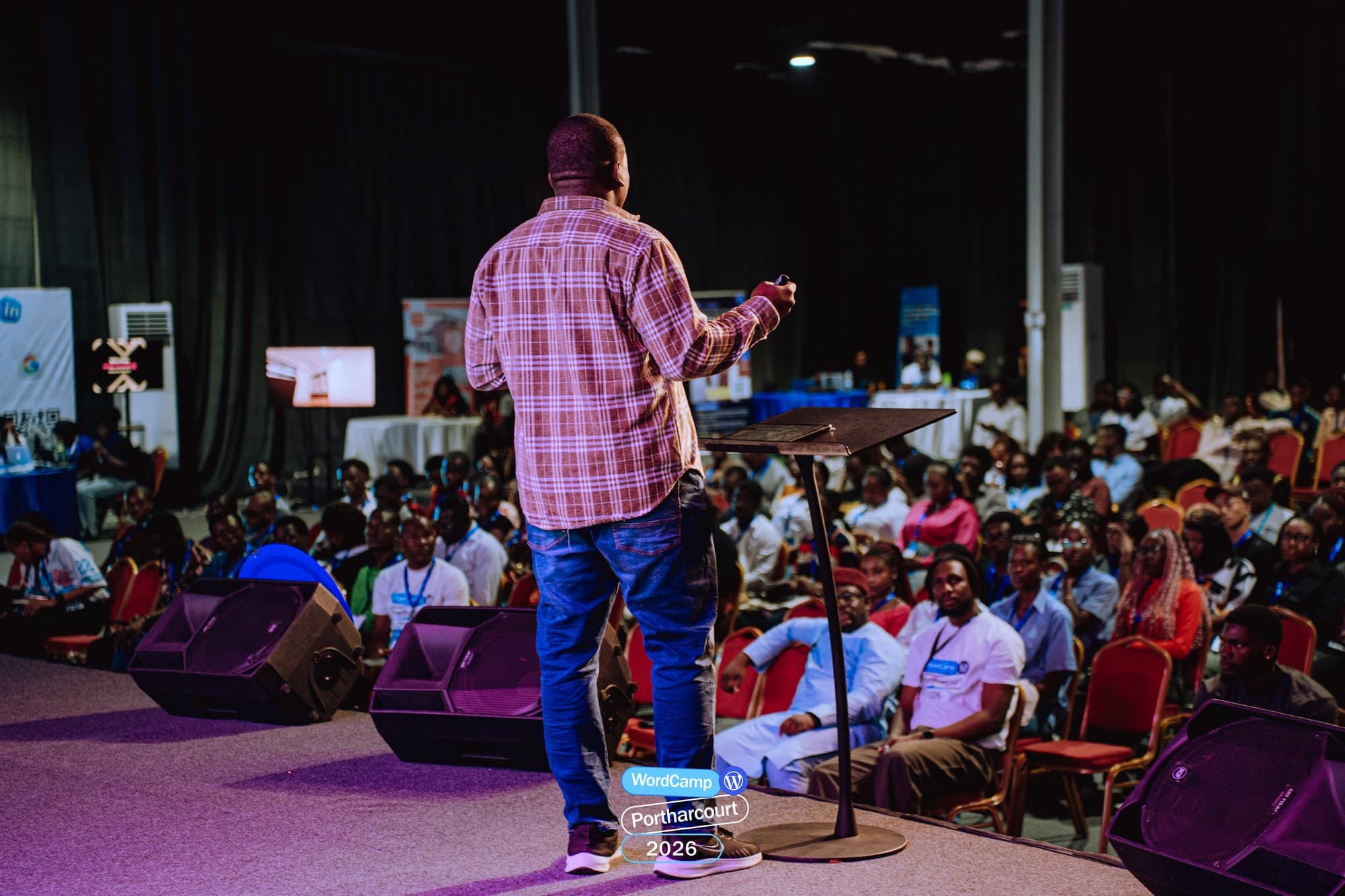 Adebayo Chike on stage, seen from behind, facing a full room at WordCamp Port Harcourt